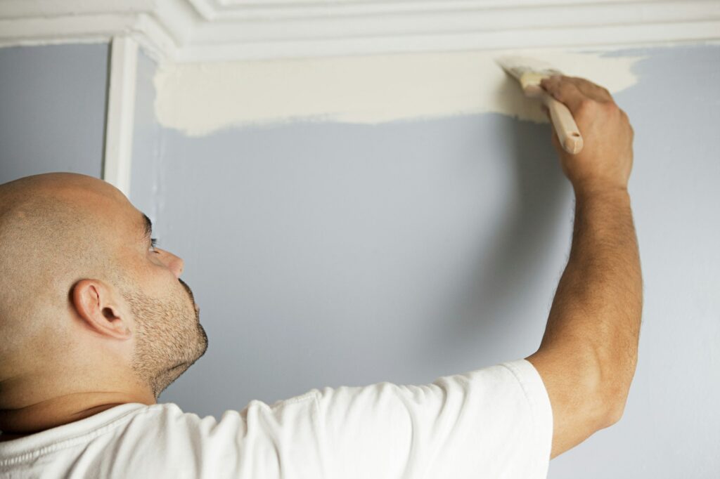 Man painting a wall in a room