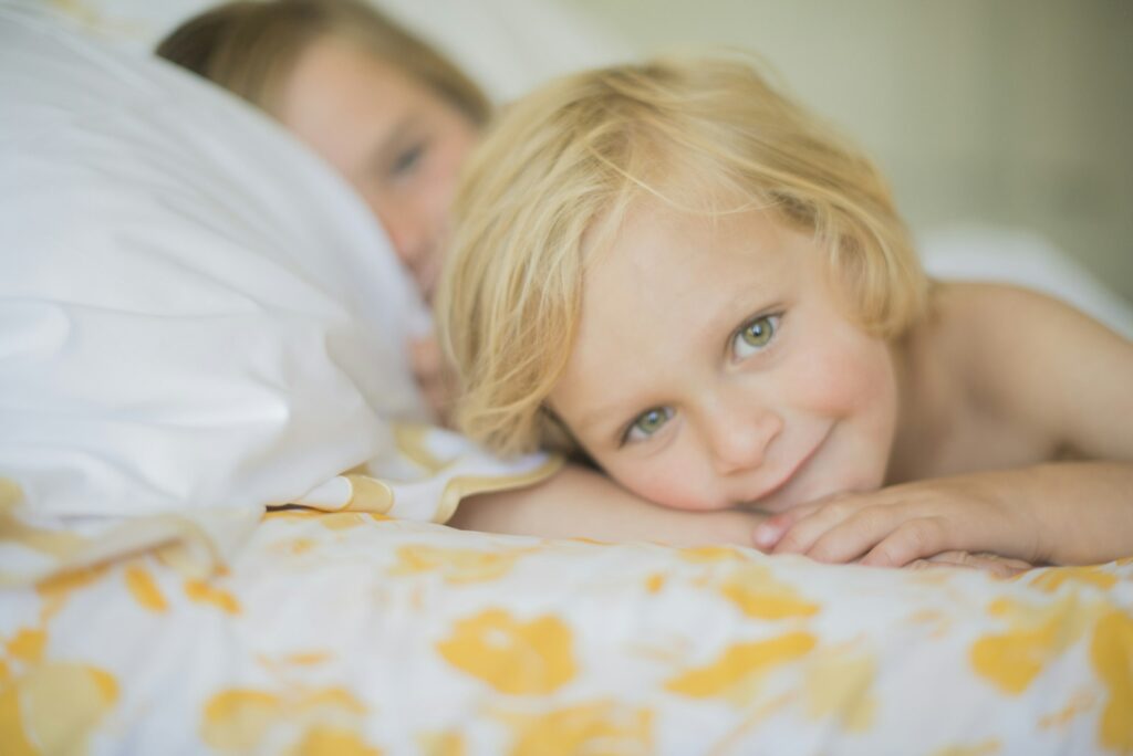 Little child enjoys a cozy moment on a bright bedspread