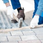 Builder laying paving tiles